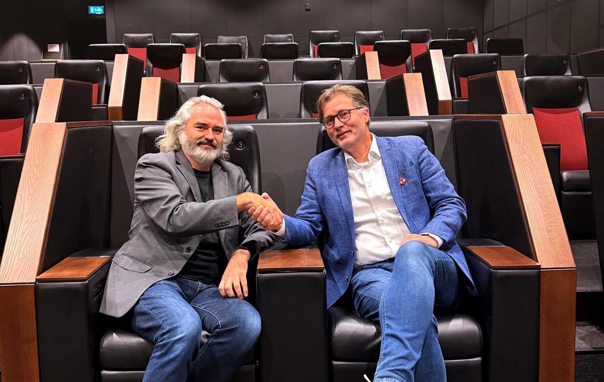 Erlend Serigstad, kinosjef Bryne kino, og Arild Kalkvik, kinodirektør i Trondheim Kino tek kverandre i hendene i lukssussalen på Bryne kino. - Klikk for stort bilete